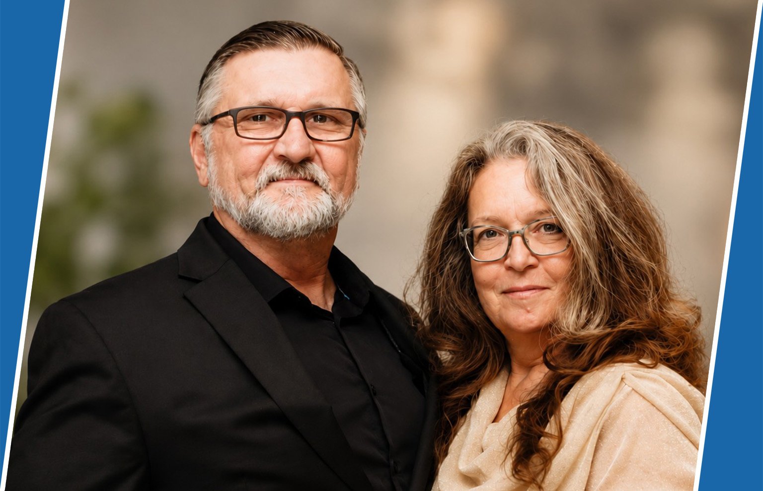 Smiling man with glasses and a gray beard beside a smiling woman with long hair