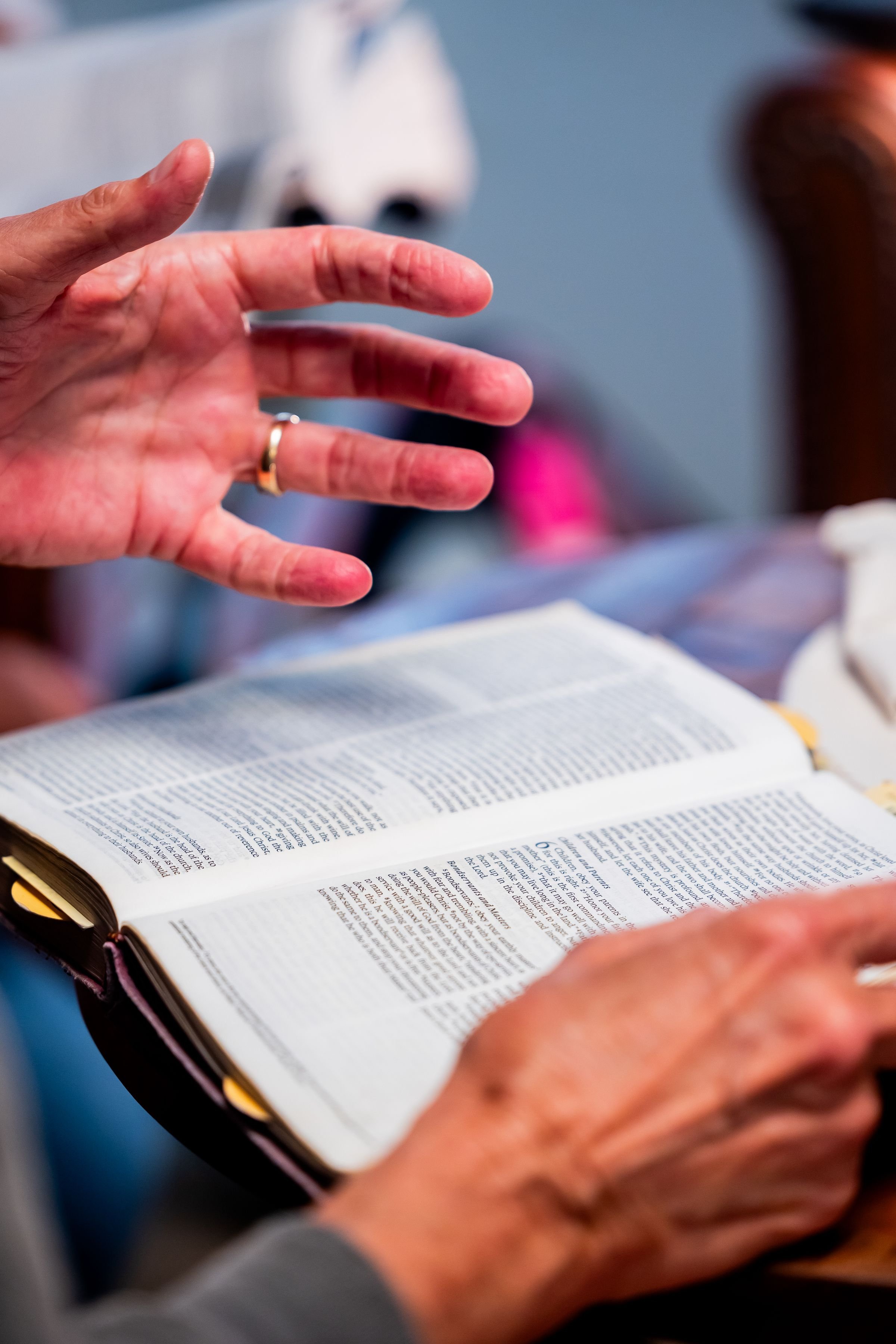 Hands resting on an open Bible