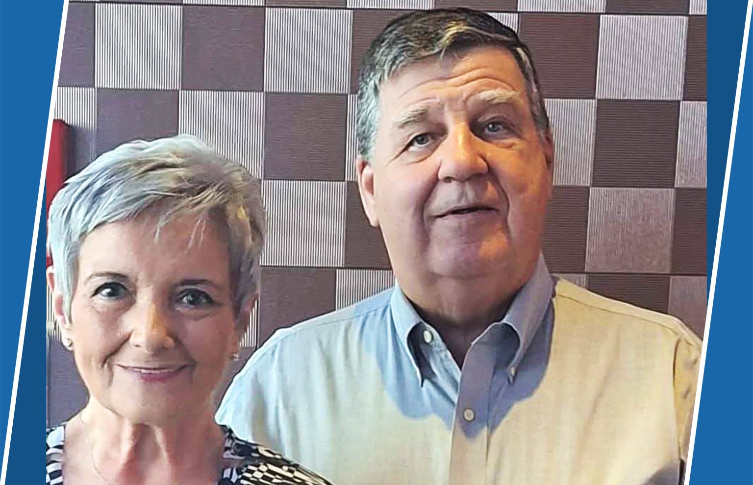 Smiling older couple posing together in front of a checkered backdrop