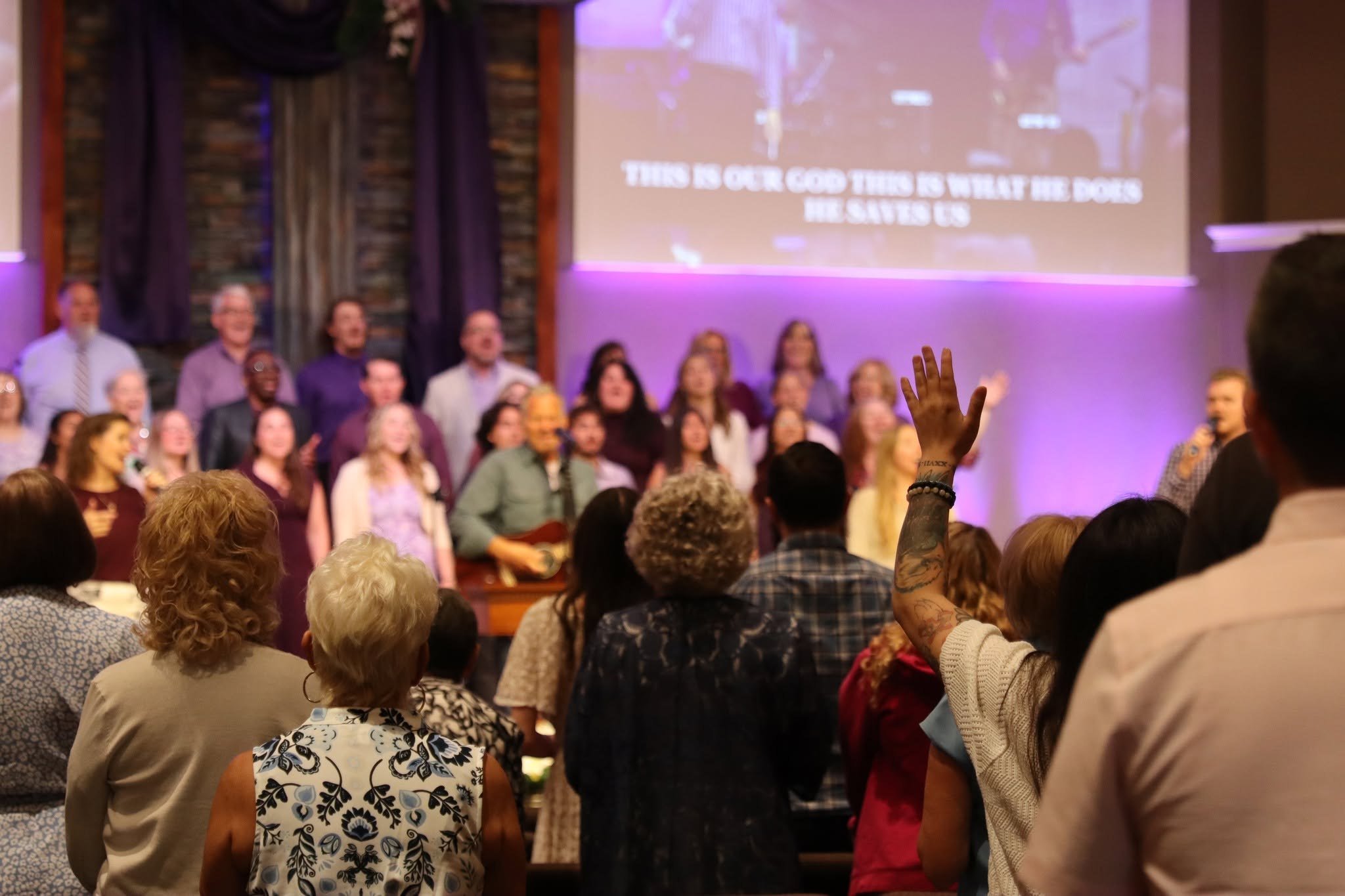 Congregation standing in worship as the choir leads
