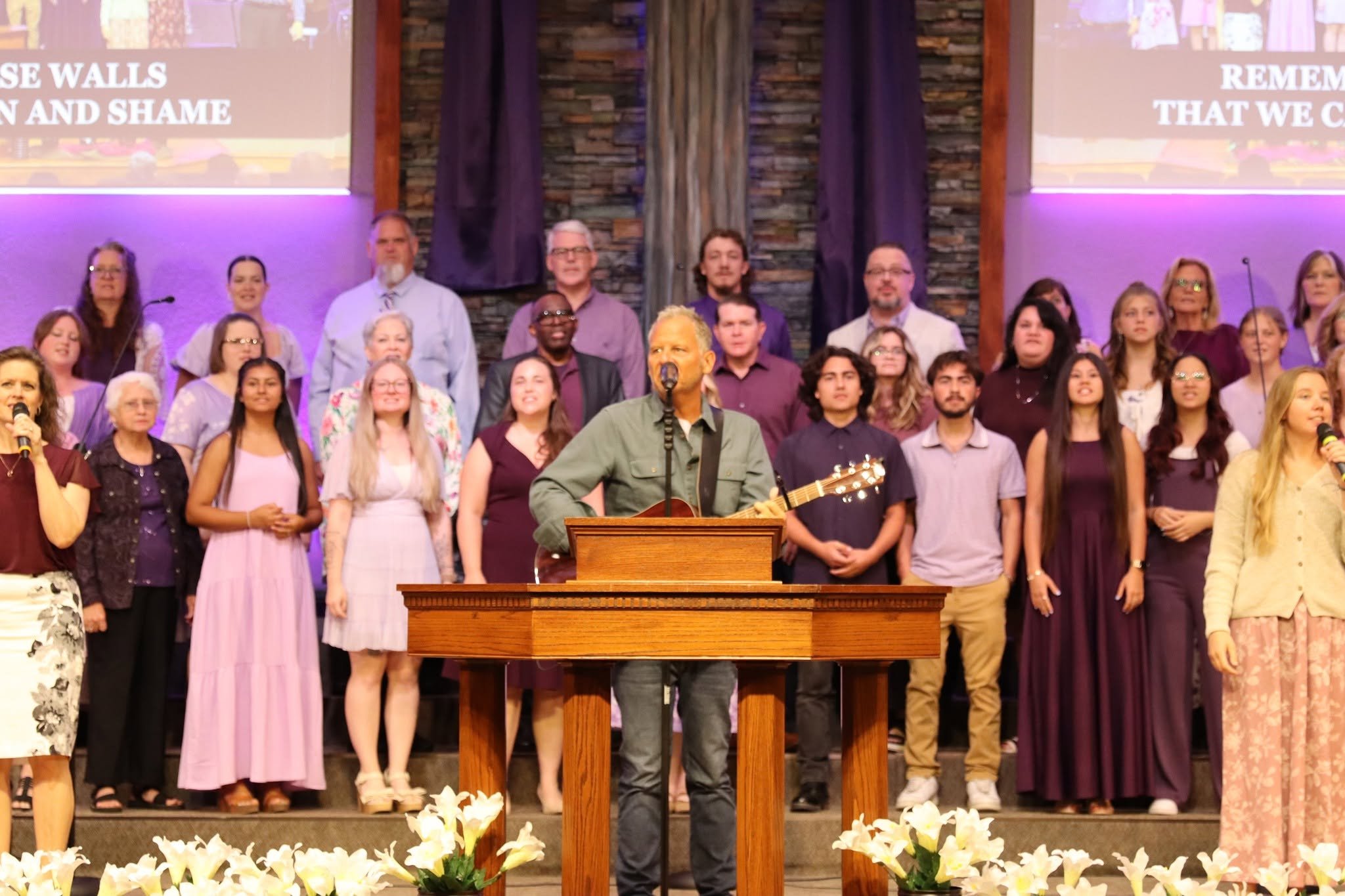 Choir standing on stage behind the pulpit during a worship service